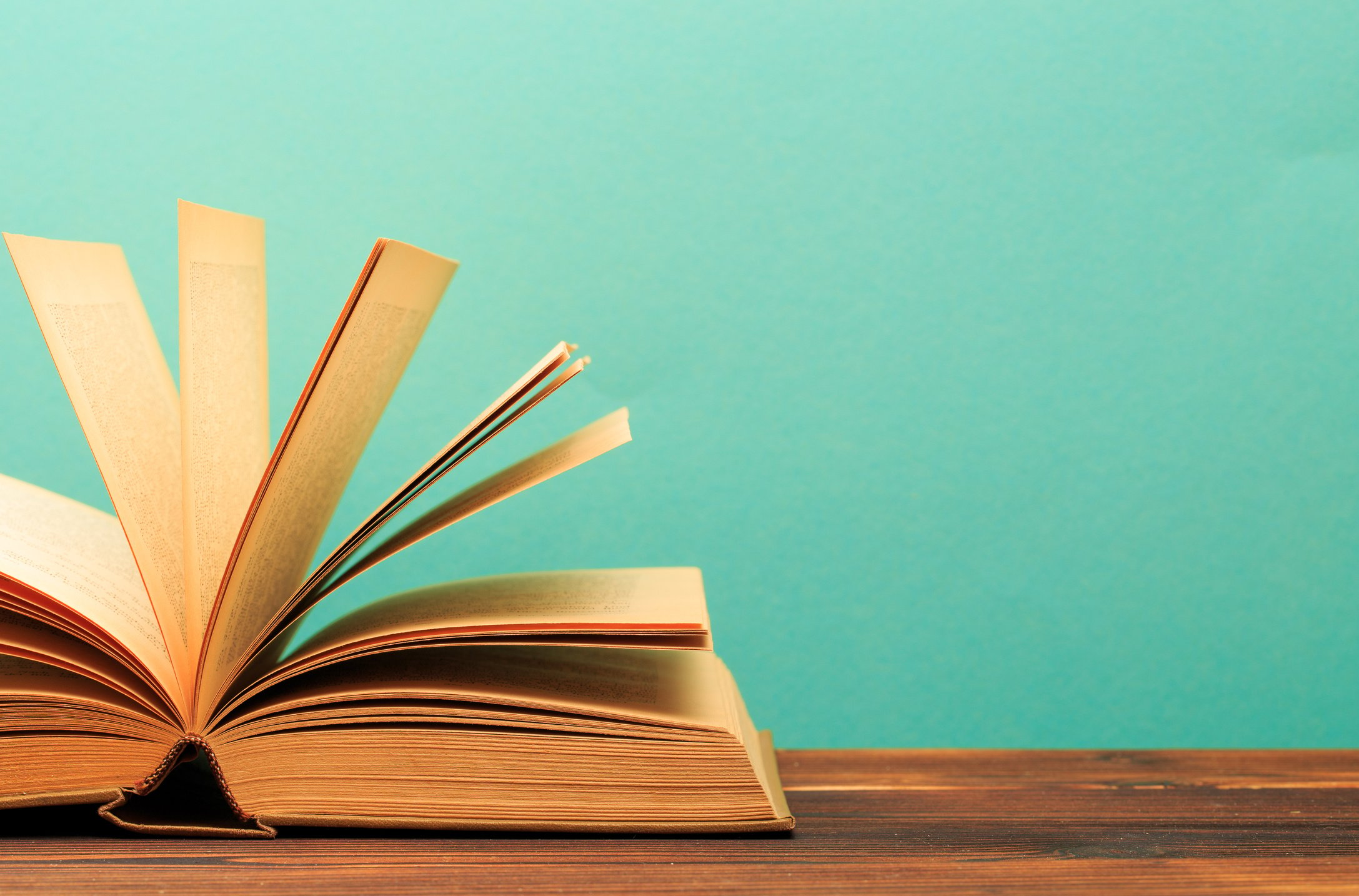 Open book on wooden vintage table blue background - Image